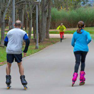 people roller skating with someone running in the distance